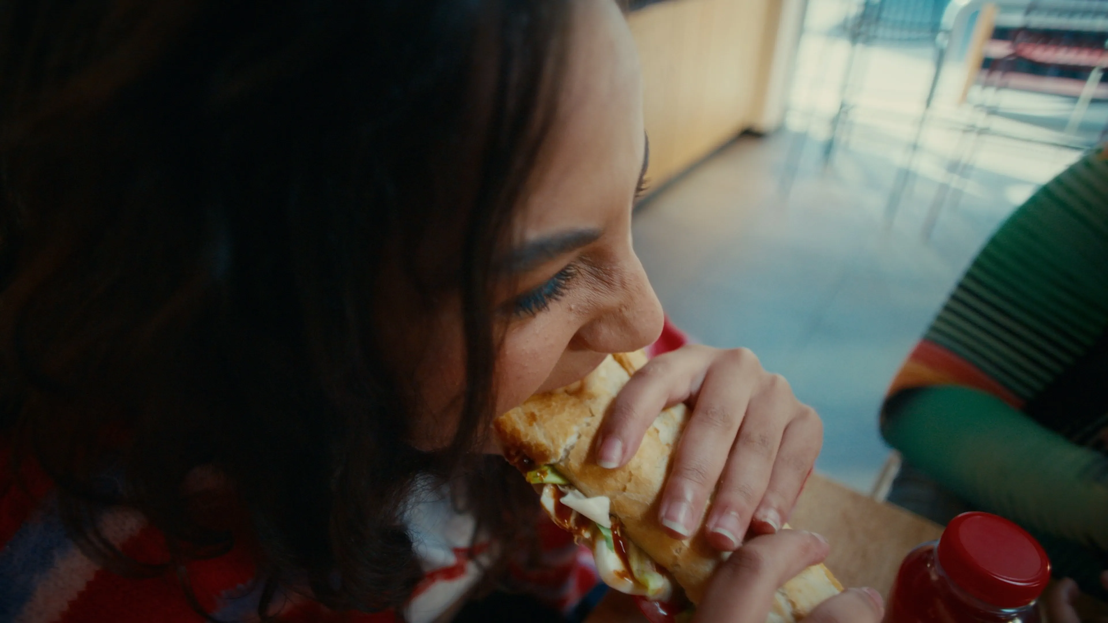 Vrouw bijt in panos broodje op Q8 station