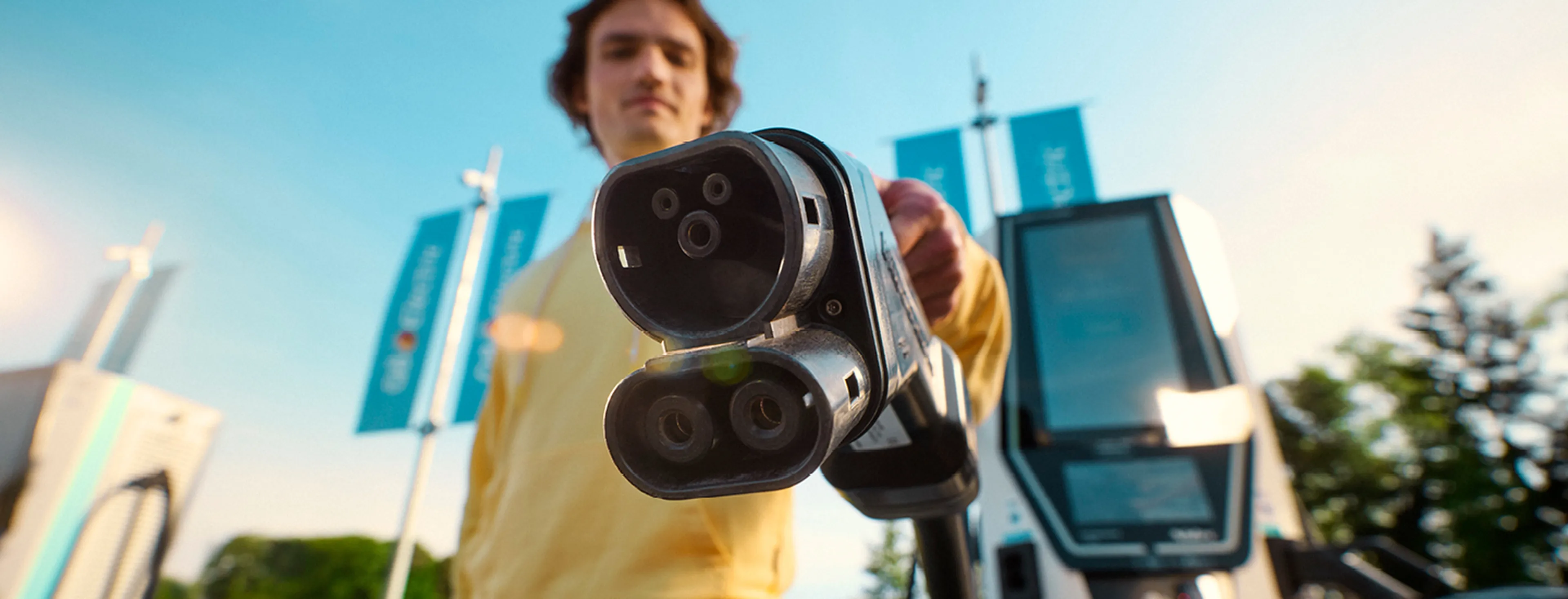 un homme chargeant à une borne de recharge Q8 avec une carte de recharge électrique Q8