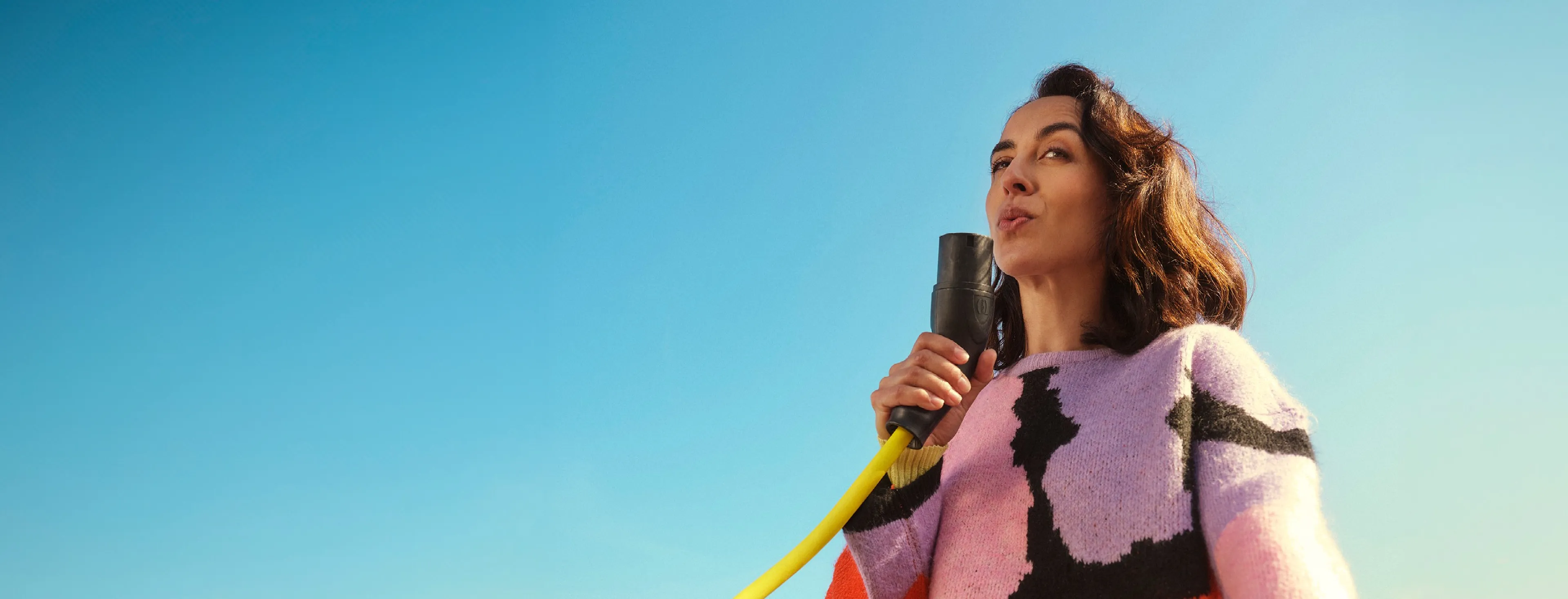 Man with charging cable near electric car, viewed from inside, at Q8.