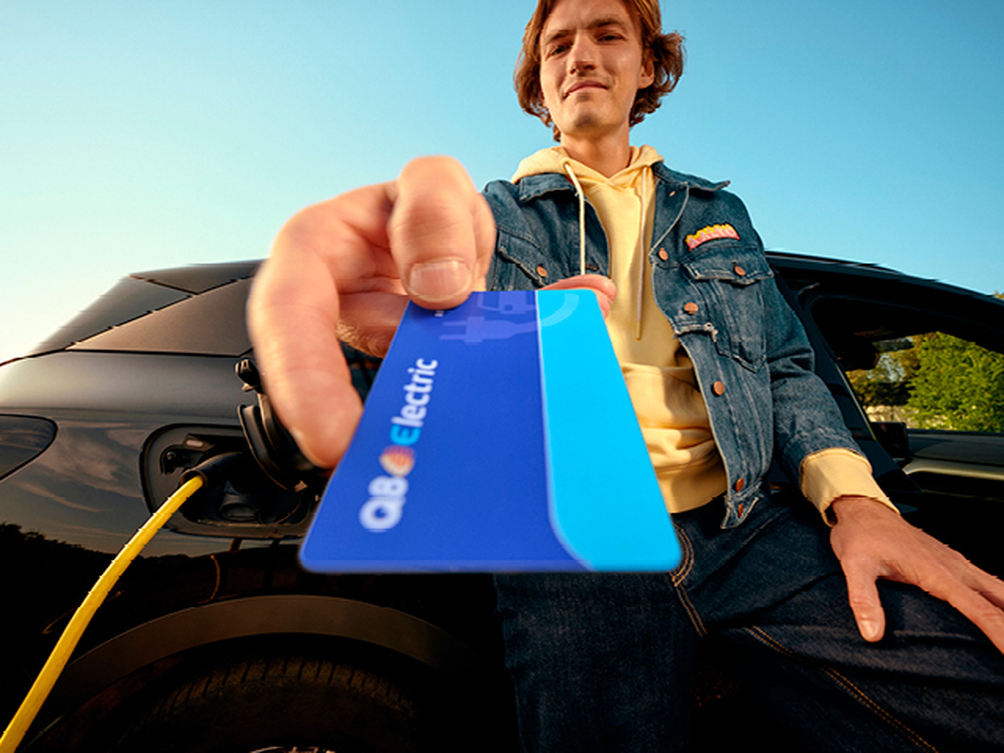 Man toont een Q8 electric laadpas bij zijn elektrische auto bij Q8.​