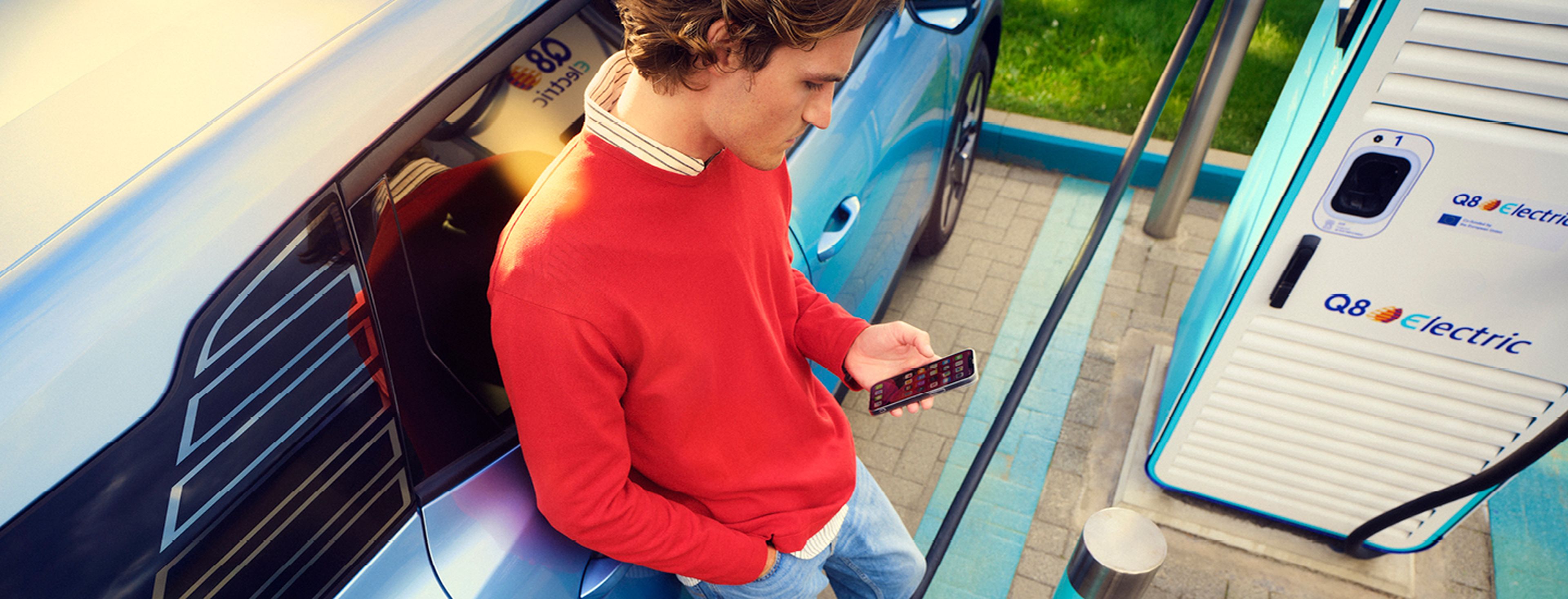 Man laadt elektrische auto op bij Q8 electric.