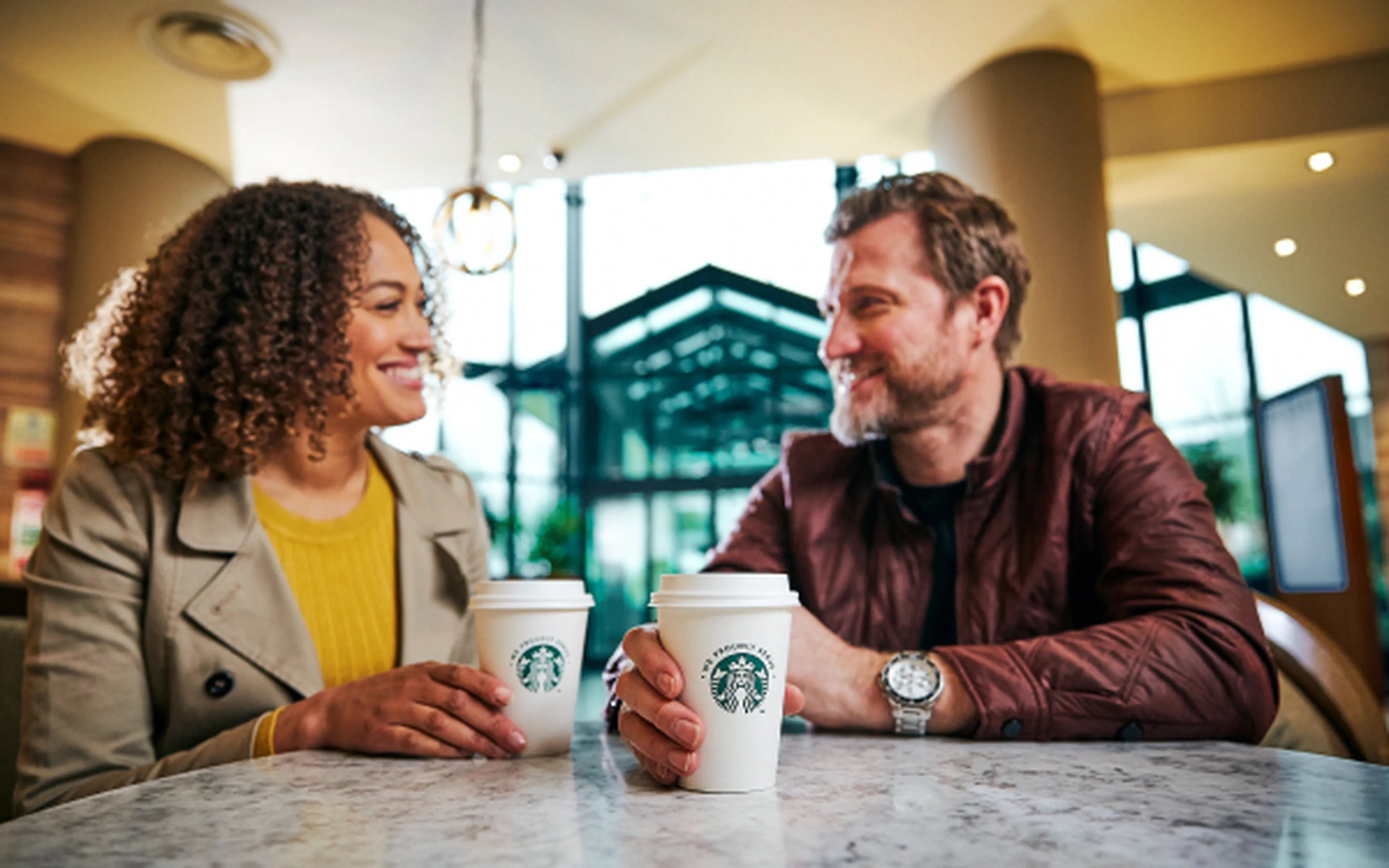 Twee mensen drinken samen Starbucks-koffie