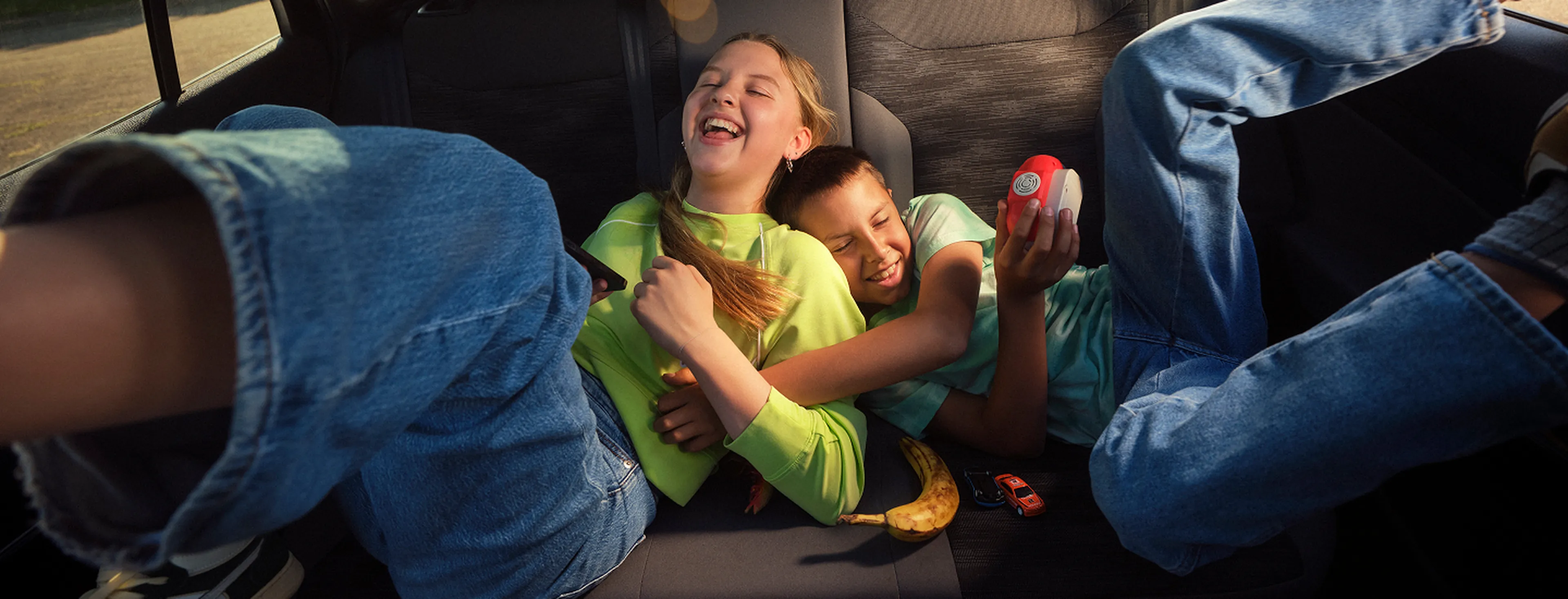 Kids laughing on the backseat of a car