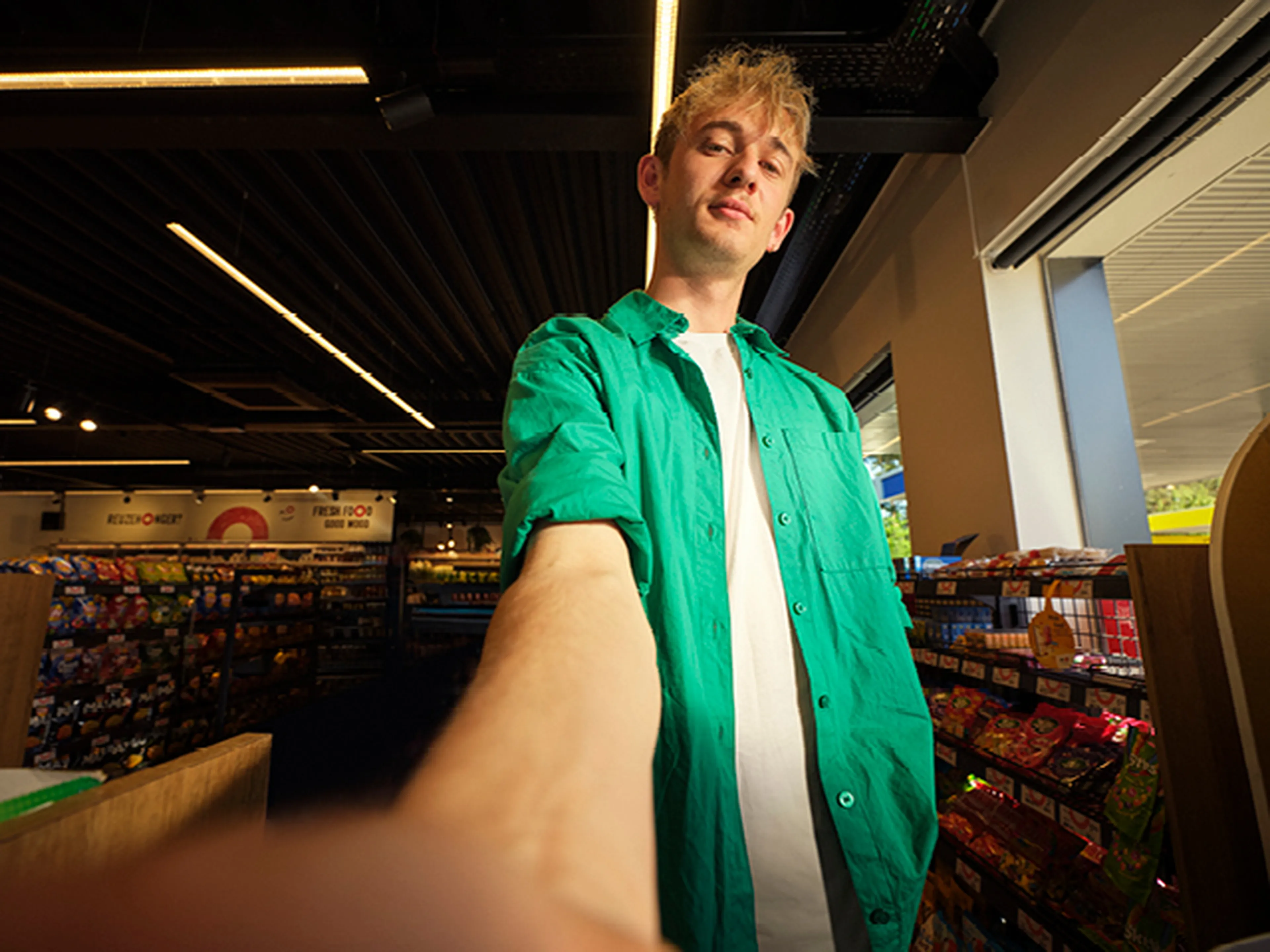 Une personne choisit des snacks dans une shop Q8, avec l’app Q8 à portée de main pour plus de facilité.