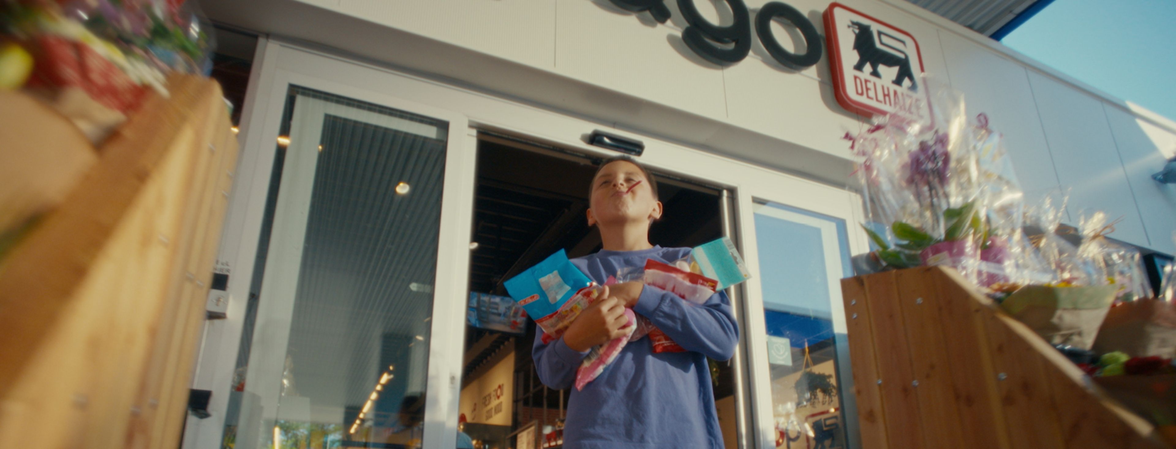 Un enfant sort avec des bonbons achetés chez Delhaize Shop & Go