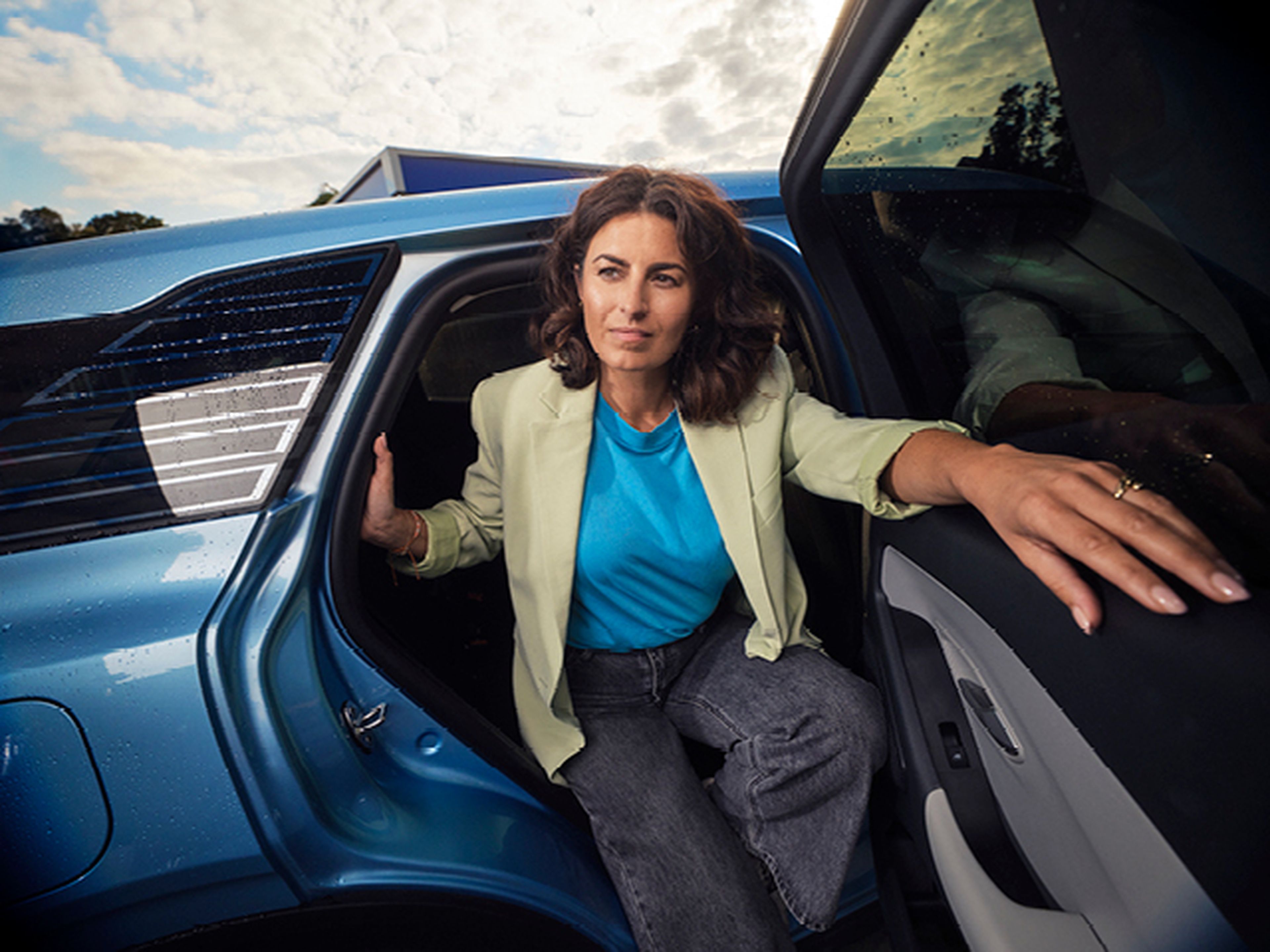Femme sort de la voiture bleue chez Q8.​